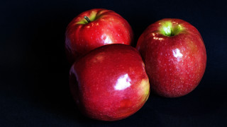 Three red apples black surface - a black surface free wallpaper