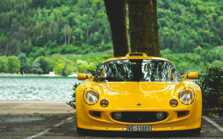 Yellow sports car parking lot 27 - a forest in the background free wallpaper