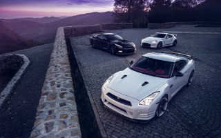 Three sports cars mountain sunset - a road near a mountain range free wallpaper