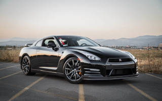 Black sports car mountains skyline - the background and a sky line in the foreground free wallpaper