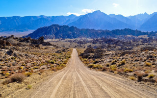 Desert dirt road mountains clouds - art brenner free wallpaper
