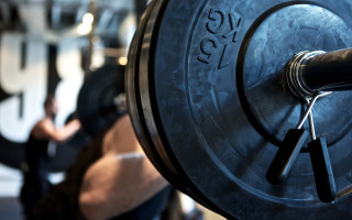 Man squatting gym bokeh depthfield - a man in the background free wallpaper