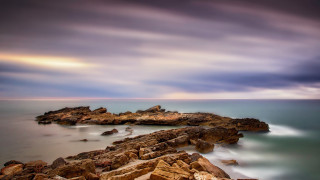 Rocky shore ocean mountains sunset - a few rock free wallpaper