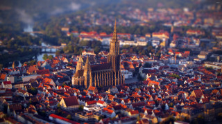 City cathedral river trees foreground - tilt shift free wallpaper