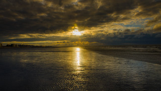 Sunset beach cityscape cloudy sky - dramatic free wallpaper