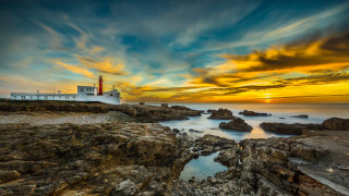 Lighthouse rocky shore sunset clouds 8 - a rocky shore free wallpaper