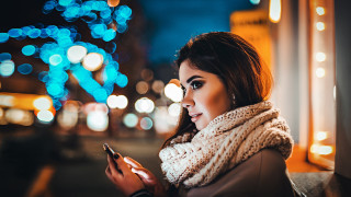 Woman scarf night city phone - a city street in the background free wallpaper