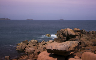 Rocky shore wave formation island - a small island in the distance free wallpaper