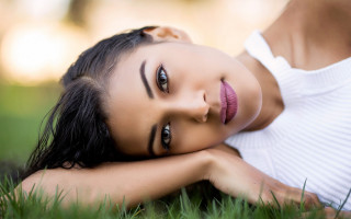 Woman laying on grass blurry - her arm free wallpaper