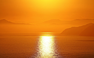 Sunset mountains ocean boat sky - a large body of water free wallpaper