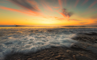 Sunset ocean waves lighthouse dusk - a lighthouse in the distance free wallpaper