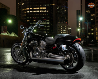 Motorcycle parked parking lot night - a city skyline in the background free wallpaper
