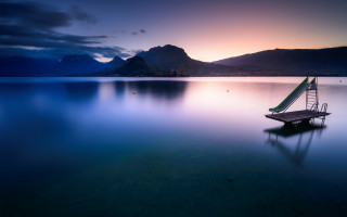 Lake sunset mountains boat ladder - top of a lake under a cloudy sky free wallpaper