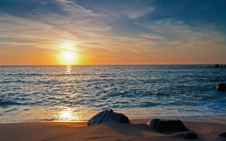 Sunset ocean rocks boat sunrise - a sunset over the ocean free wallpaper