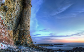 Rock wall sky water landscape - a sky background and a body of water free wallpaper