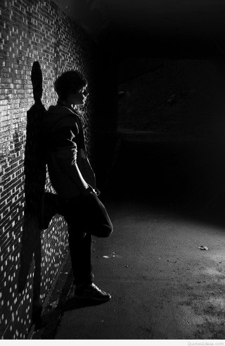 Man leaning brick wall dark - dramatic free wallpaper