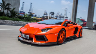 Bright orange sports car city 2 - tall building free wallpaper