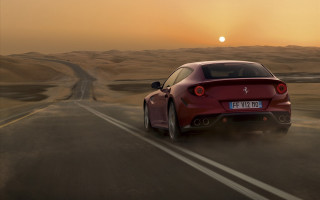 Red sports car desert road 16 - the sun in the distance behind free wallpaper