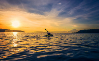 Kayak paddling sunset mountain water - a mountain in the distance free wallpaper