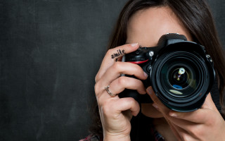 Woman camera pose jewelry nail - a black background behind her free wallpaper