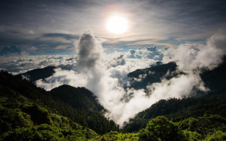 Mountain range clouds trees sun - volumetric free wallpaper