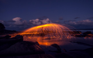 Firework night sky reflection water - rock free wallpaper