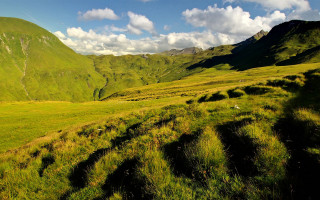 Grassy valley mountains clouds nature - free landscape wallpaper