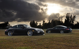 Black sports cars field cloudy - the sun behind them free wallpaper