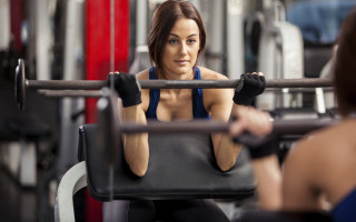 Gym squatting woman blurry background - facial muscle free wallpaper