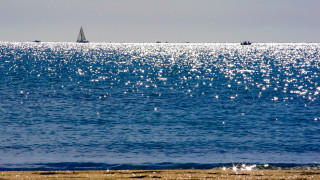 Sailboat ocean beach city sunset - a sailboat free wallpaper