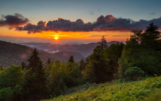 Sunset mountain range trees bushes - a sunset over a mountain range free wallpaper