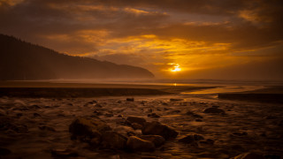 Sunset rocky beach mountain water 3 - a sunset over a rocky beach free wallpaper