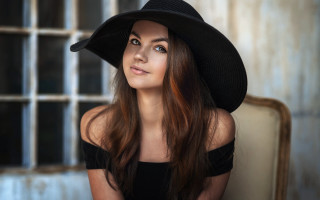 Woman black hat dress chair 2 - a window behind her free wallpaper