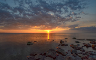 Sunset water rocks city lights - a sunset over a body of water free wallpaper