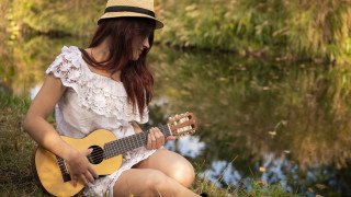 Woman playing guitar outdoors nature - her head and a hat free wallpaper