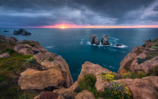 Rocky coastline sunset beach landscape - the foreground and a sunset in the background free wallpaper