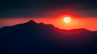 Sunset mountain range bright sun - a dark sky above free wallpaper