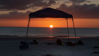 Sunset beach tent people lighthouse - a few person free wallpaper