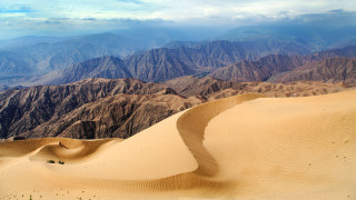 Desert mountains sky clouds land - the background and a sky line in the foreground free wallpaper
