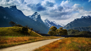 Dirt road grassy field mountains 2 - a grassy field free wallpaper