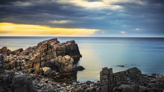 Rocky outcropping ocean clouds sunbeam - a rocky outcropping free wallpaper