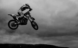 Man dirtbike air over hill - cloudy free wallpaper