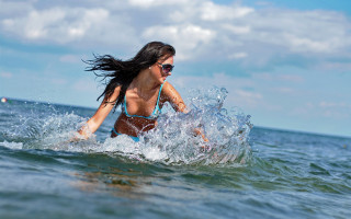 Woman bikini surfing ocean sunny - flowing hair free wallpaper