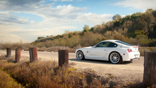 White sports car dirt road 2 - a cloudy sky in the background free wallpaper