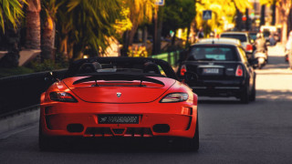 Red sports car driving black - the side of the road free wallpaper