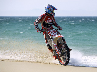 Man riding dirt bike beach - dusty free wallpaper