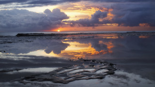 Sunset reflections clouds water rocks - over a body of water free wallpaper