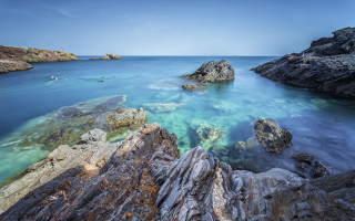 Rocky beach water boats sky - a few boat free wallpaper