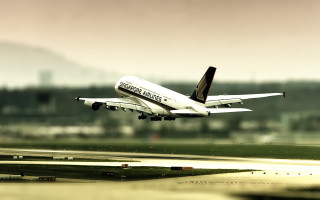 Large jet flying over runway - an airport free wallpaper