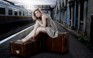 Woman sitting suitcase train station - a train free wallpaper